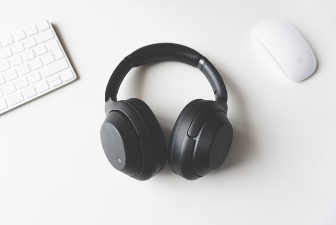 black-wireless-headphones-between-apple-keyboard-and-apple-magic-mouse-on-white-surface-ydzpdqv3fca